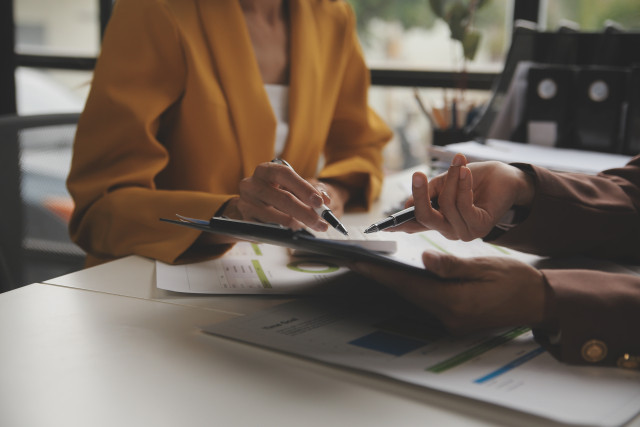 business women pointing at reports
